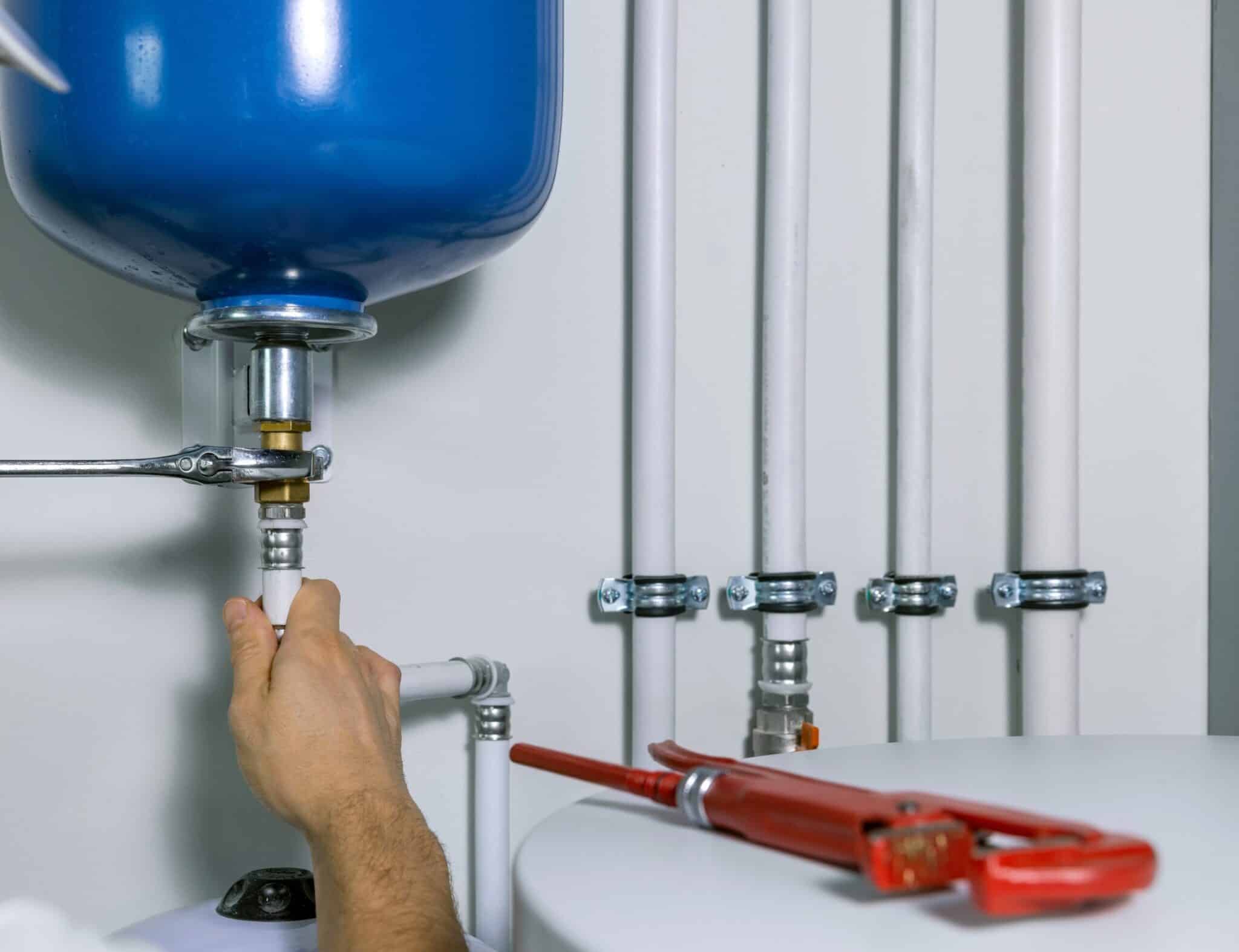 A plumber installing an expansion tank for a house heating system.