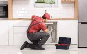 Fixing a pipe under sink in a modern kitchen, Plumbing Service Near Me.