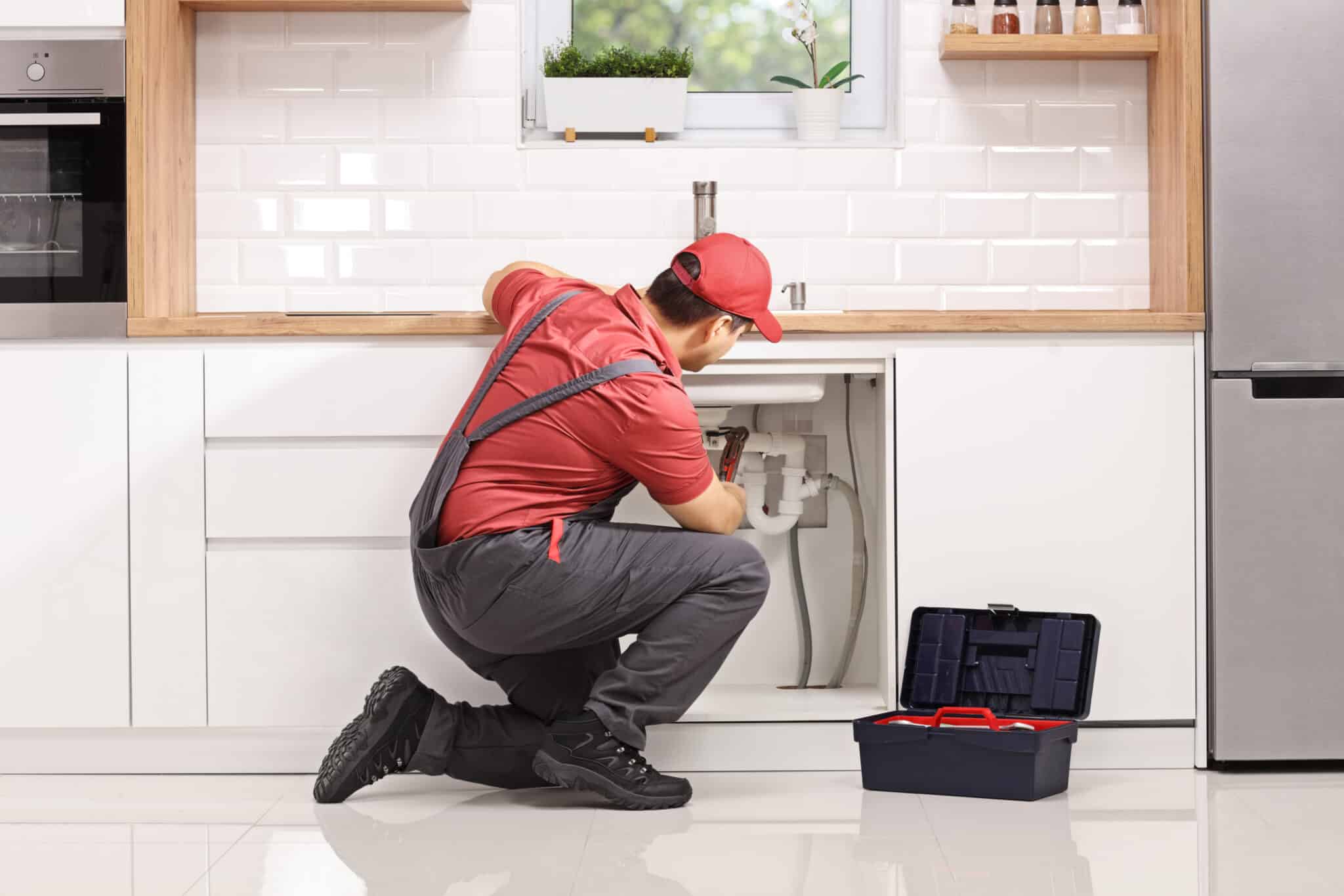 Fixing a pipe under sink in a modern kitchen, Plumbing Service Near Me.