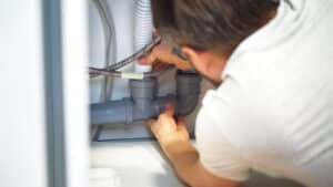 Plumber repairs plumbing pipes in sink, Major Plumbing Failures.